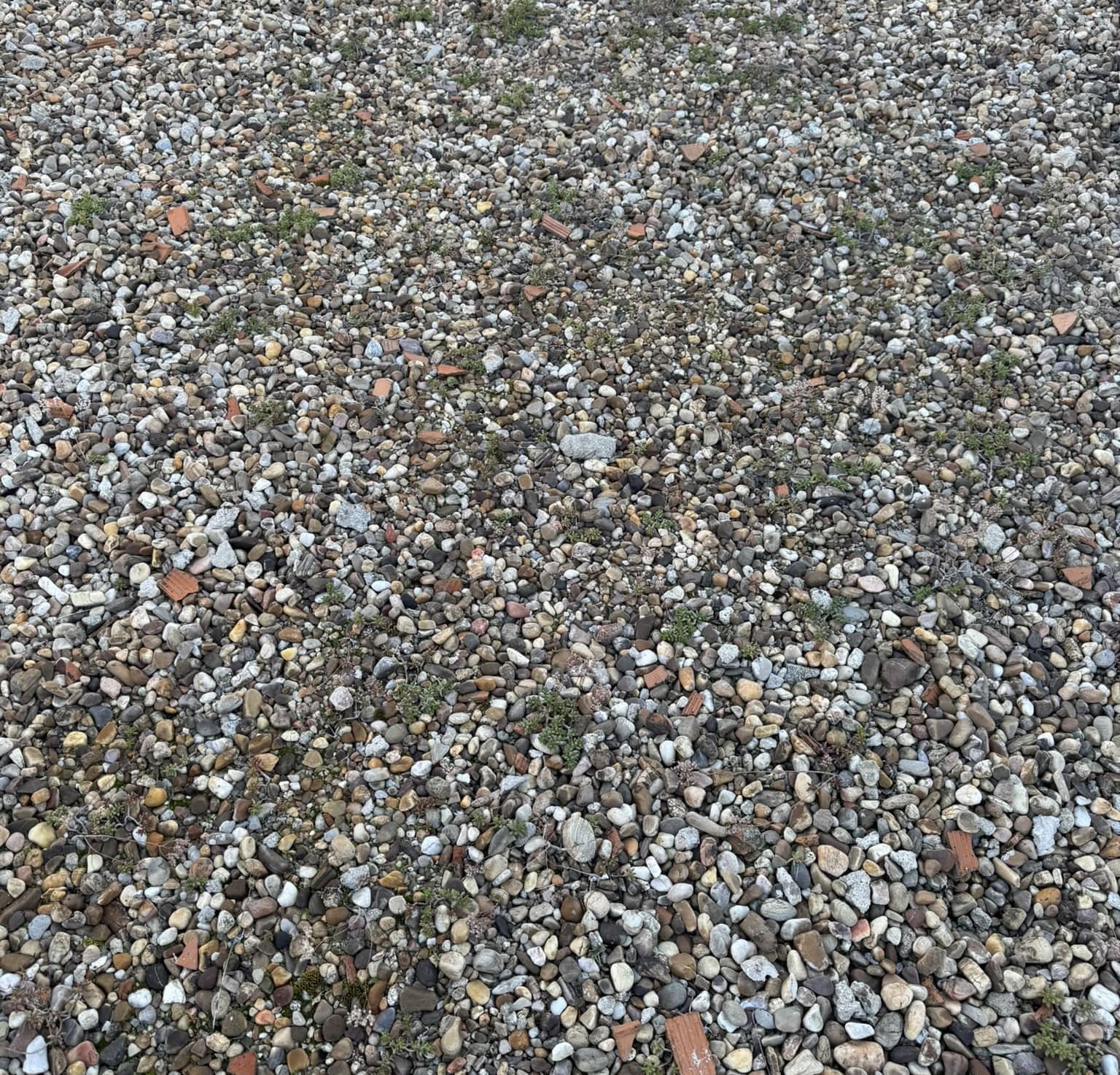Cubierta de azotea con grava para drenaje en edificio residencial en Madrid.